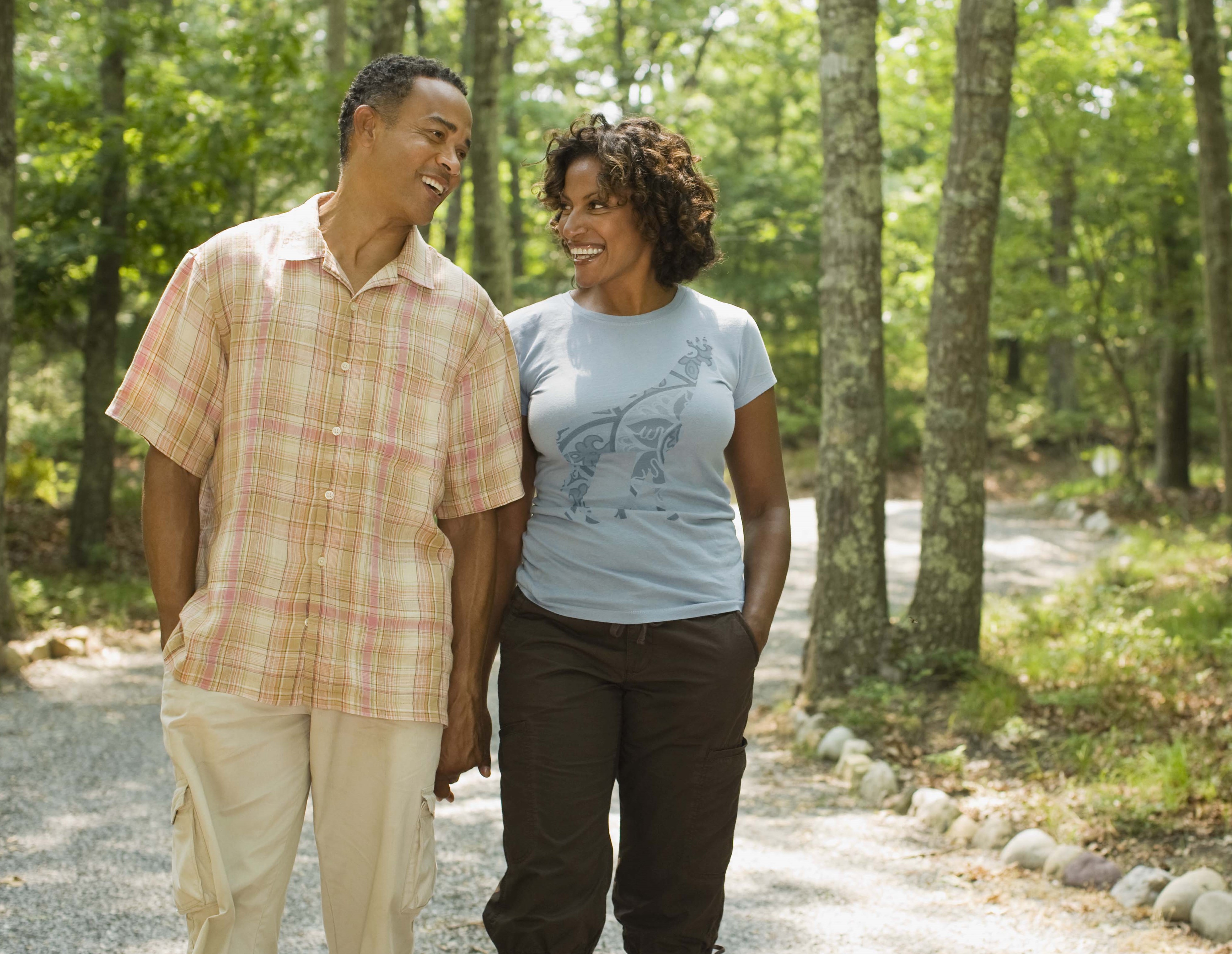 Couple walking hand-in-hand through Northwest American woodlands